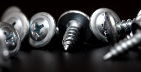 Sharp screws on a black background.の写真素材
