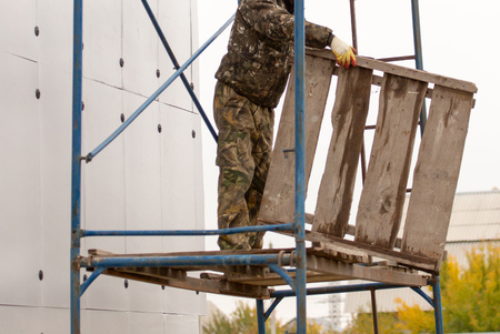 Worker on the construction of wall insulation in the house.の写真素材