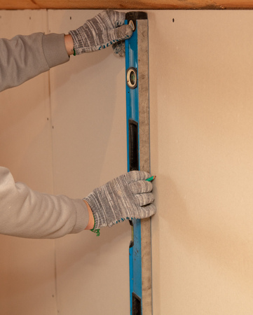 Worker installs drywall on the walls in the room.の写真素材