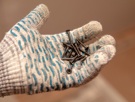 Screws in the hand of a worker.の写真素材