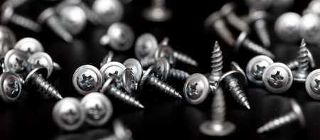 Sharp screws on a black background.の写真素材