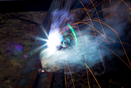 Sparks from welding at a construction site as a background.