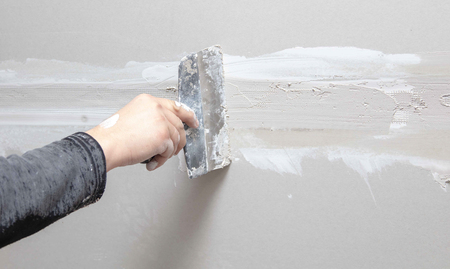 Worker aligns the walls with plaster. Repair in the house.の写真素材
