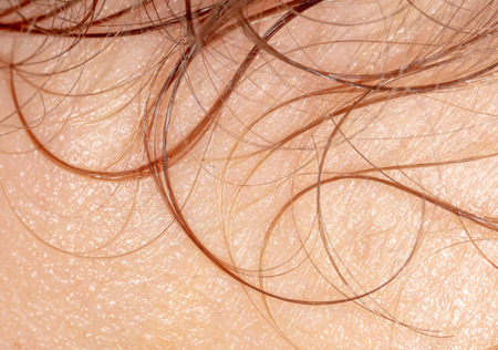 Curly hair on human skin as background, Macro .