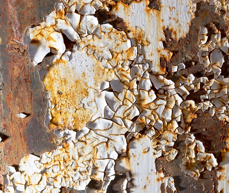 Cracked paint on rusty metal as abstract background .