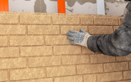 Installing brick siding on the wall of the house .の写真素材