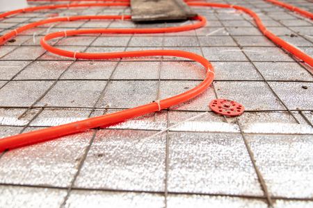 Installing a hose for underfloor heating in the room.の写真素材