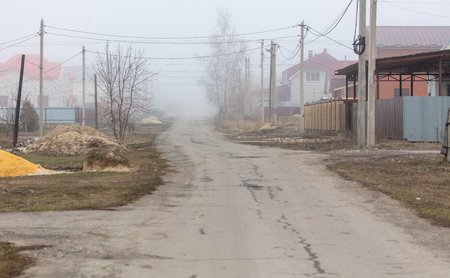 Road in a cottage settlement in the fog.の写真素材