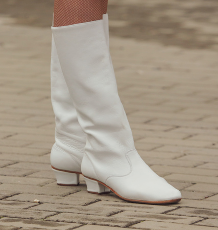Feet girl in white boots on the pavement .の写真素材