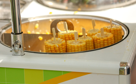 Corn is boiled in a pan in the market .の写真素材