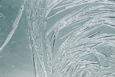 Snow patterns on glass as an abstract background .
