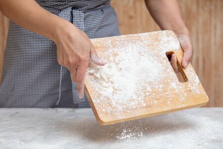 Mistress pours flour in the kitchen .