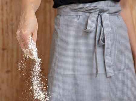 Mistress pours flour in the kitchen .
