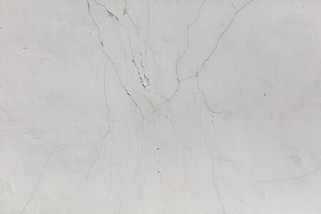 White wall with cracked plaster as abstract background.