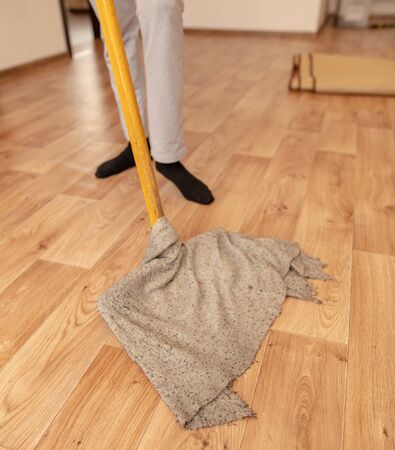The girl washes the floor with a rag in the room.の写真素材