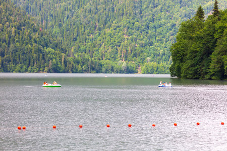 Lake Ritsa, Abkhazia - June 7, 2019: People swim in boats on Lake Ritsa .のeditorial素材