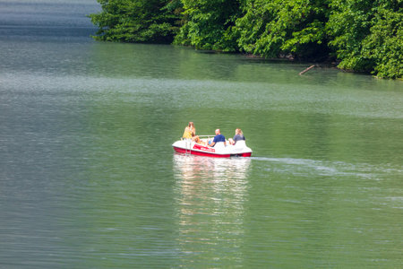 Lake Ritsa, Abkhazia - June 7, 2019: People swim in boats on Lake Ritsa .