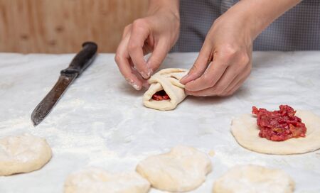The hostess prepares the pies in the kitchen .