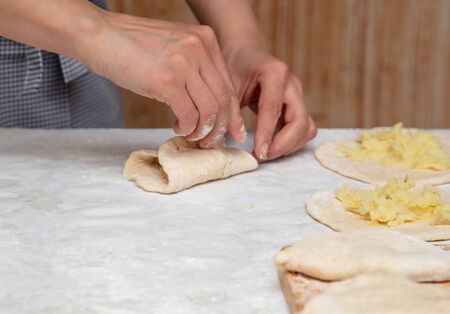 The hostess prepares the pies in the kitchen .