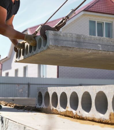 A crane raised a concrete slab at a construction site at home .の写真素材