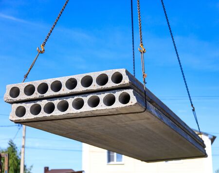 A crane raised a concrete slab at a construction site at home .の写真素材