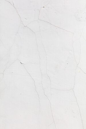 White wall with cracked plaster as abstract background.