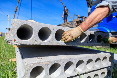 A crane raised a concrete slab at a construction site at home .