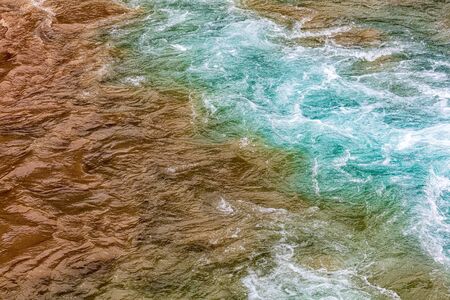 Dirty and clear water mixed in the river .の写真素材