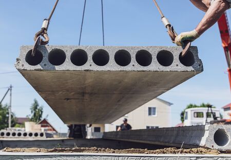 A crane raised a concrete slab at a construction site at home .の写真素材