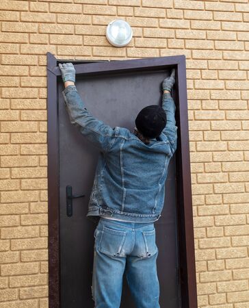The worker installs a metal door in the house .の写真素材