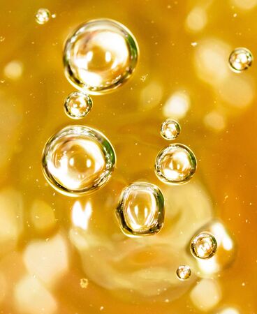 Bubbles of air on the smooth surface of golden water as an abstract background .の写真素材