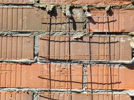 Brick laying in the wall at a construction site at home .