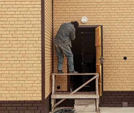 The worker installs a metal door in the house .の写真素材
