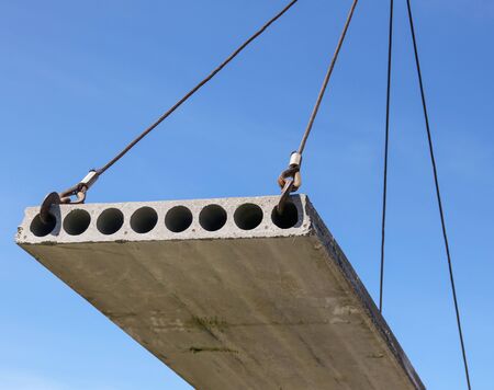 A crane raised a concrete slab at a construction site at home .の写真素材