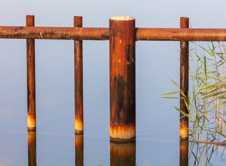 Rusty metal pipes in a pond in nature .の写真素材