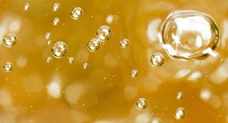 Bubbles of air on the smooth surface of golden water as an abstract background .の写真素材