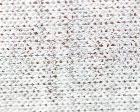 Knitted light surface of wool things as a background. Closeup of gray texture knitting patterns....