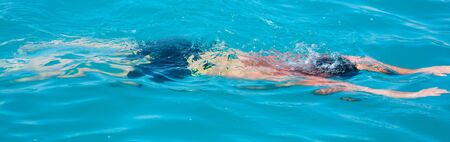 A man swims in the water. Summer vacation at sea