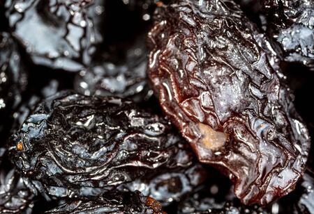 Black dry raisins as background. Macro