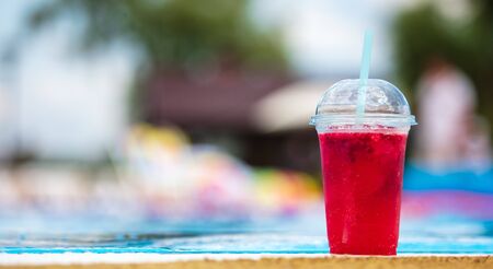 Red cocktail by the pool .