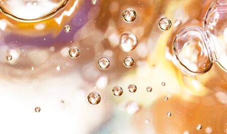 Bubbles of air on the smooth surface of golden water as an abstract background .の写真素材