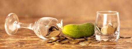 Coins in a glass cup in cucumbers .