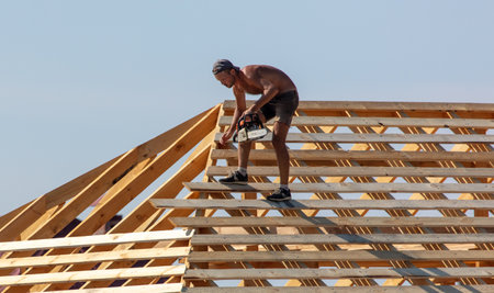 Lipetsk, Russia - August 30, 2019: Workers work with a tree on the roof of the house. Construction of the cottage.のeditorial素材