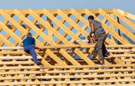 Lipetsk, Russia - August 30, 2019: Workers work with a tree on the roof of the house. Construction of the cottage.のeditorial素材