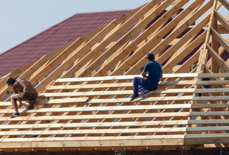Lipetsk, Russia - August 30, 2019: Workers work with a tree on the roof of the house. Construction of the cottage.のeditorial素材