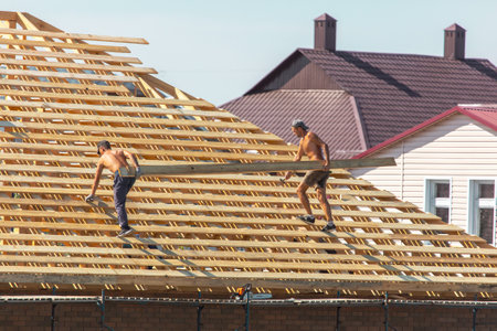 Lipetsk, Russia - August 30, 2019: Workers work with a tree on the roof of the house. Construction of the cottage.のeditorial素材