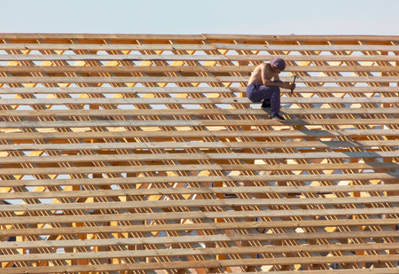 Lipetsk, Russia - August 30, 2019: Workers work with a tree on the roof of the house. Construction of the cottage.のeditorial素材