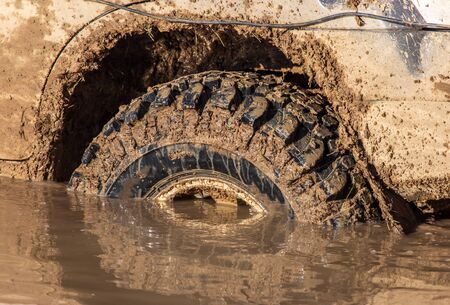SUV wheel stalled in mud and water.の写真素材
