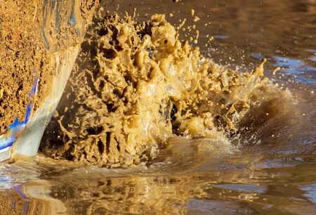 SUV wheel stalled in mud and water.の写真素材