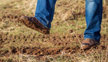 Dirt and soil on a manâ€™s shoe in a park.